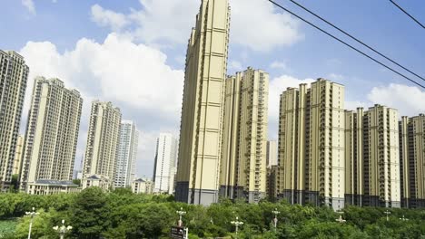 scenic train ride in china, showcasing towering apartments with lush greenery in the foreground
