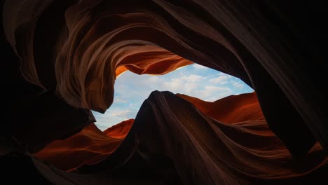 time lapse of blue sky and moving clouds framed by lower antelope canyon sandstone rock walls, arizona