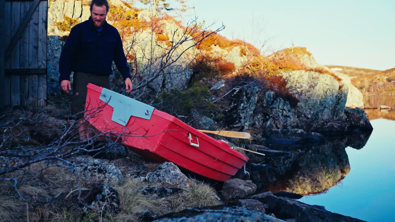A Man Prepares to Launch a Small Boat Into the Serene Waters of Reinsjøen in Åfjord, Trøndelag, Norway - Static Shot