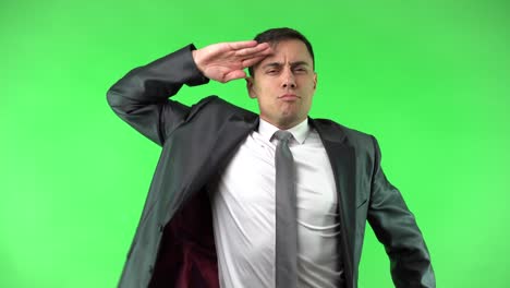 a man in a suit saluting and smiling on a green screen