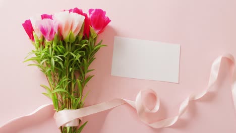 Video-of-pink-and-white-flowers-and-card-with-copy-space-on-pink-background