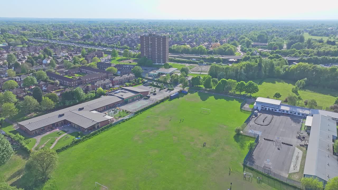 Aerial View Of Suburban Play Park, Green Football Field Next to Residential Area and Suburbs Highway, Lostock Park Manchester