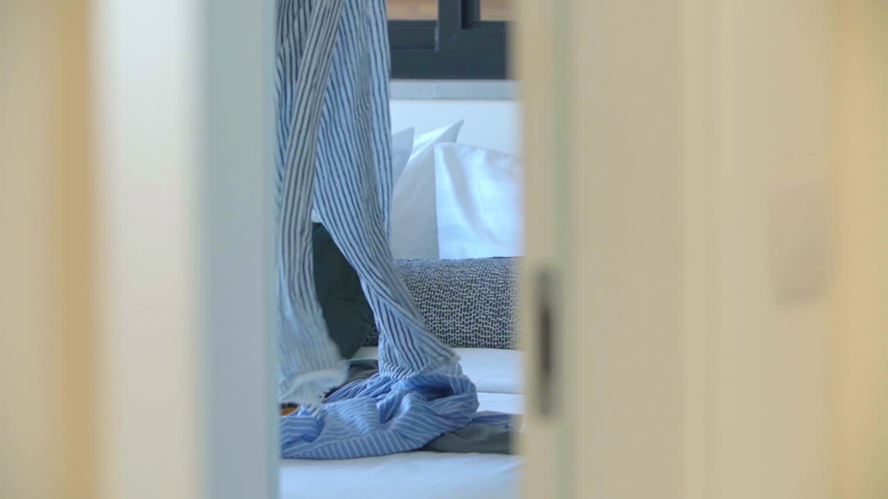 카메라는 은 문을 통해 어보고, 세탁을 접는 젊은 여성의 라이프 스타일 이미지를 포착합니다.