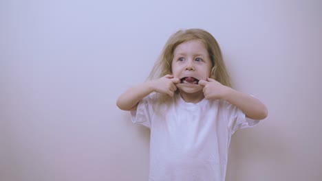 Una-Chica-Divertida-Con-Camiseta-Hace-Cara-Mostrando-La-Lengua-En-La-Pared