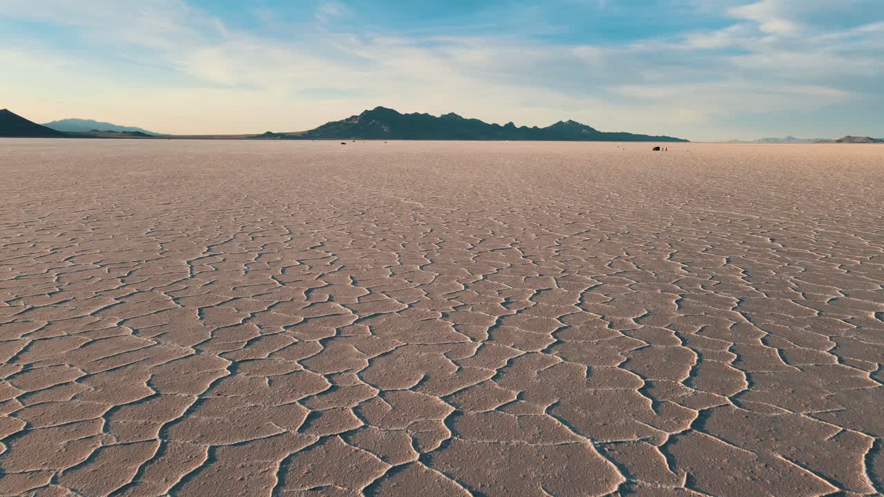 el avión no tripulado asciende por encima de las salinas de bonneville en utah, el coche y la gente en la distancia