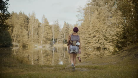 female explorer with backpack exploring by lake