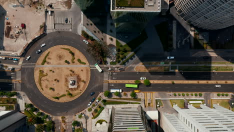 Aerial-birds-eye-overhead-top-down-view-of-cars-driving-on-roundabout-between-skyscrapers-in-modern-Santa-Fe-district.-Ascending-camera-footage.-Mexico-City,-Mexico.