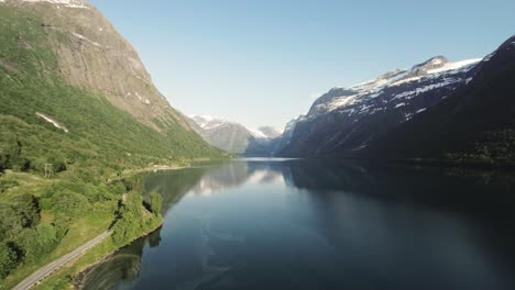 coastal road and majestic lake lovatnet, aerial drone view