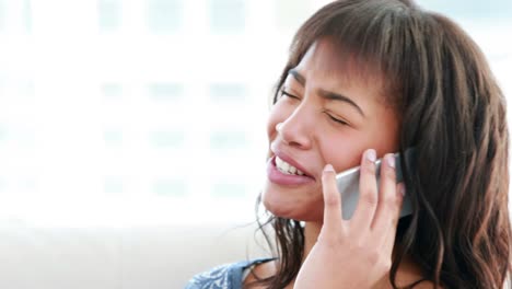 Smiling-woman-phoning-on-the-sofa-