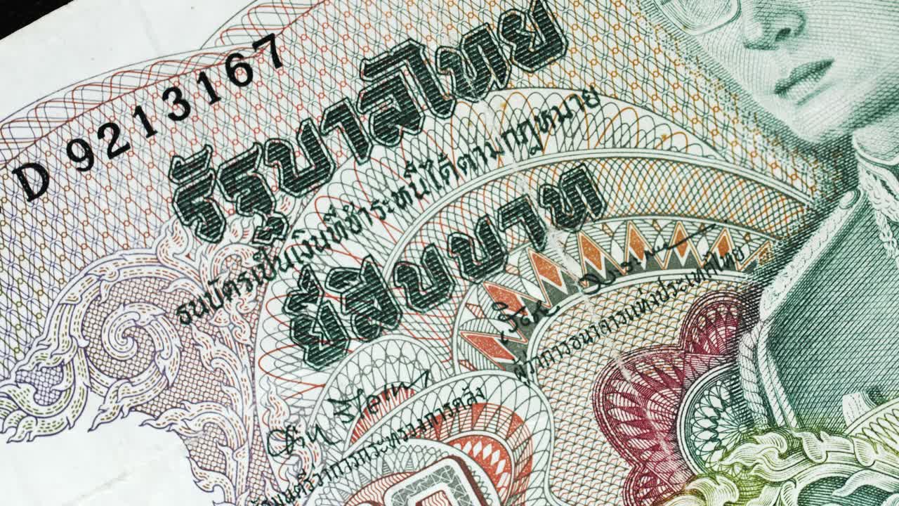 Thailand 20 Baht banknote obverse with royal portrait and Thai script detail rotating on black background