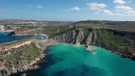 Luftdrohnenansicht-über-Einen-Tropischen-Sandstrand-Mit-Klarem-Türkisfarbenem-Wasser,-Die-Bucht-Von-Qarraba,-Die-Bucht-Von-Ghajn-Tuffieha-Und-Die-Lehmklippen,-Malta