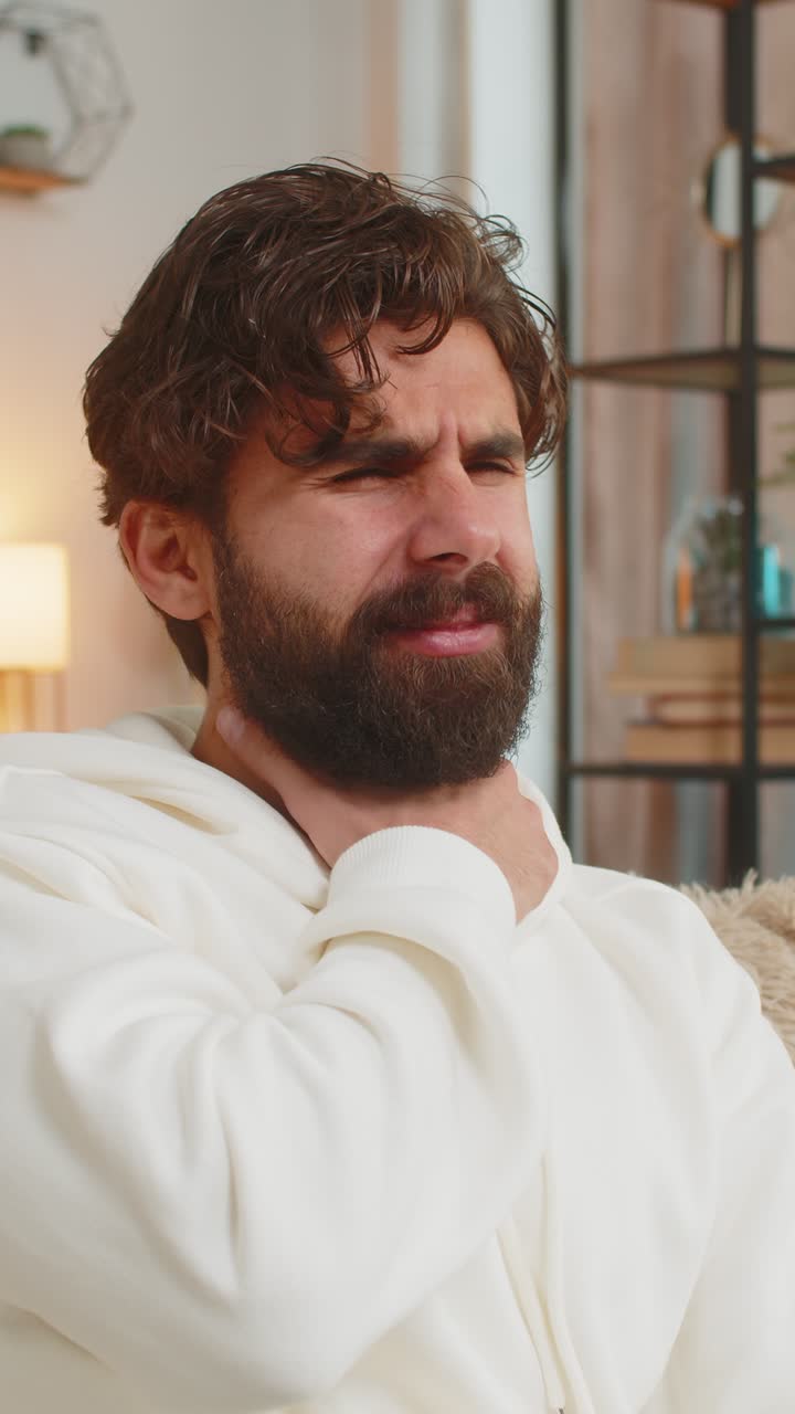 Upset indian young man holds hand over sore throat suffering sore throat tonsils inflammation