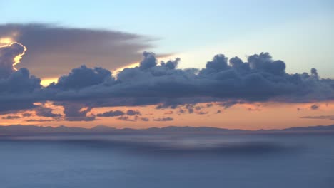 Dramatic-sunset-behind-clouds-from-titicaca-lake-ocean-island-of-Amantani-on-temple-of-mother-earth,-panning-long-shot