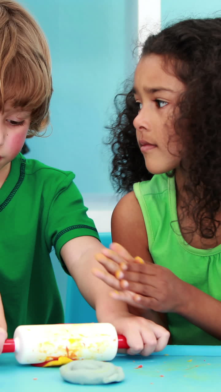 niños pequeños usando arcilla de modelado