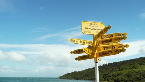 tiwai point in bluff new zealand with waypoint post pointing to iconic cities around the world