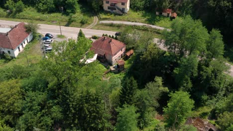 Vista-Del-Cielo-De-Los-Exuberantes-árboles-Verdes-Que-Rodean-El-Pueblo-Pacífico-De-Ticje-Polje-En-La-Montaña-Jadovnik-Prijepolje-Serbia-Durante-El-Día---Toma-Aérea