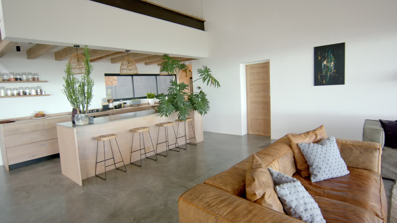 Modern living room with leather sofa and kitchen island with bar stools