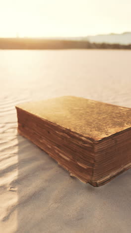 old book on the beach at sunrise