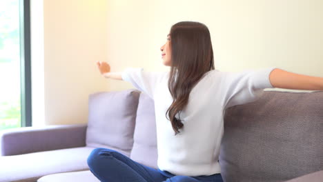 집에서 평화로운 냉기를 즐기며 눈을 감고 손을 뻗는 지친 여성
