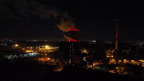 night view of a power plant with smoke