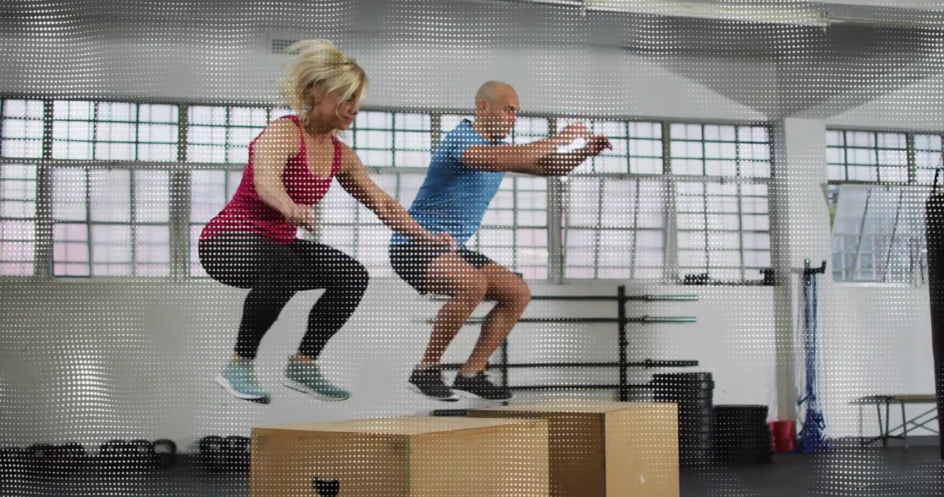 Compagni di allenamento che si piegano in uno squat, eseguendo salti sincronizzati sopra i plyo box per il cardio.