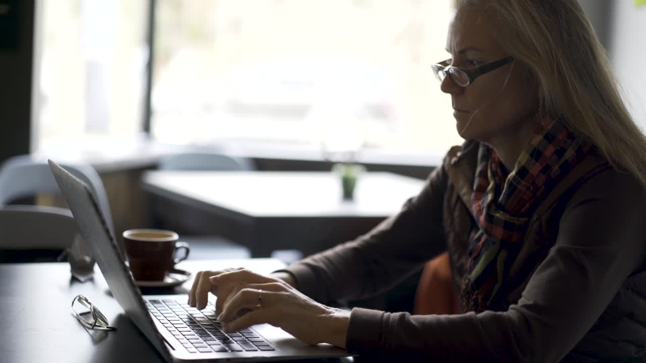 Woman working on laptop in a cafe