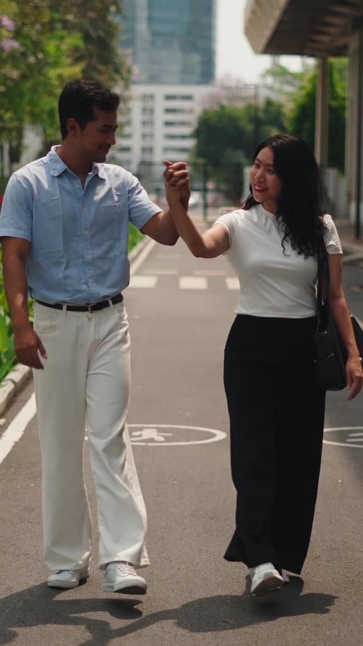 Couple walking hand in hand on a city street