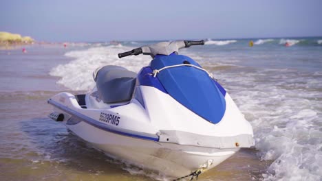 slow-motion-shot-of-a-speedboat-on-the-coast-on-a-sunny-day,-waves-crashing