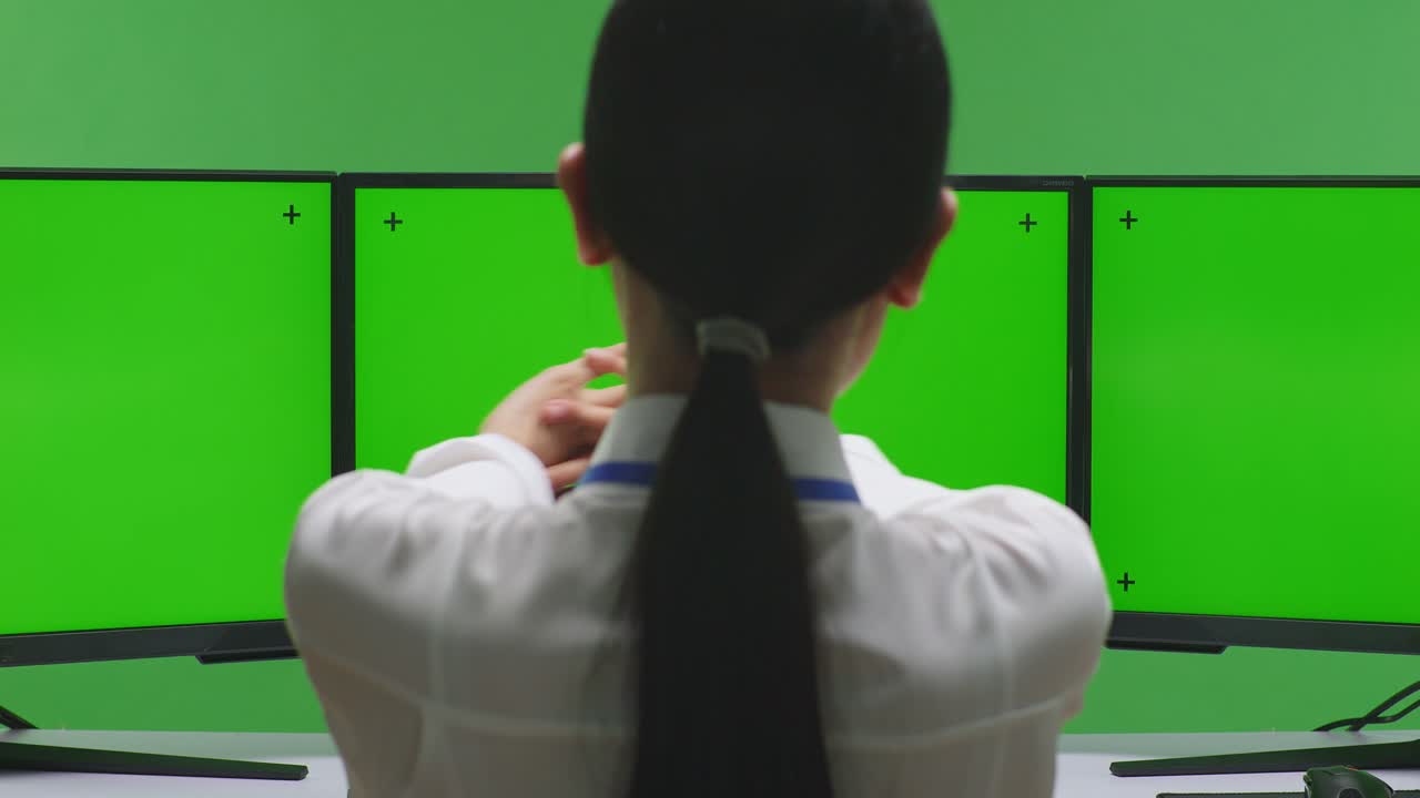 녹색 스크린에서 여러 모니터를 보는 여자