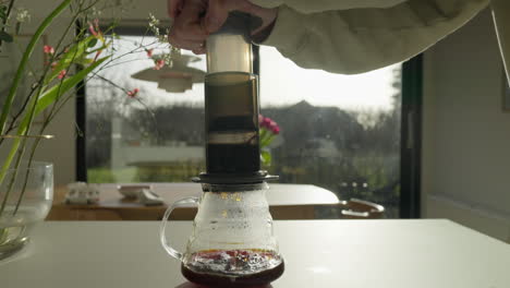 prensa de café operada a mano en una cocina moderna iluminada por el sol