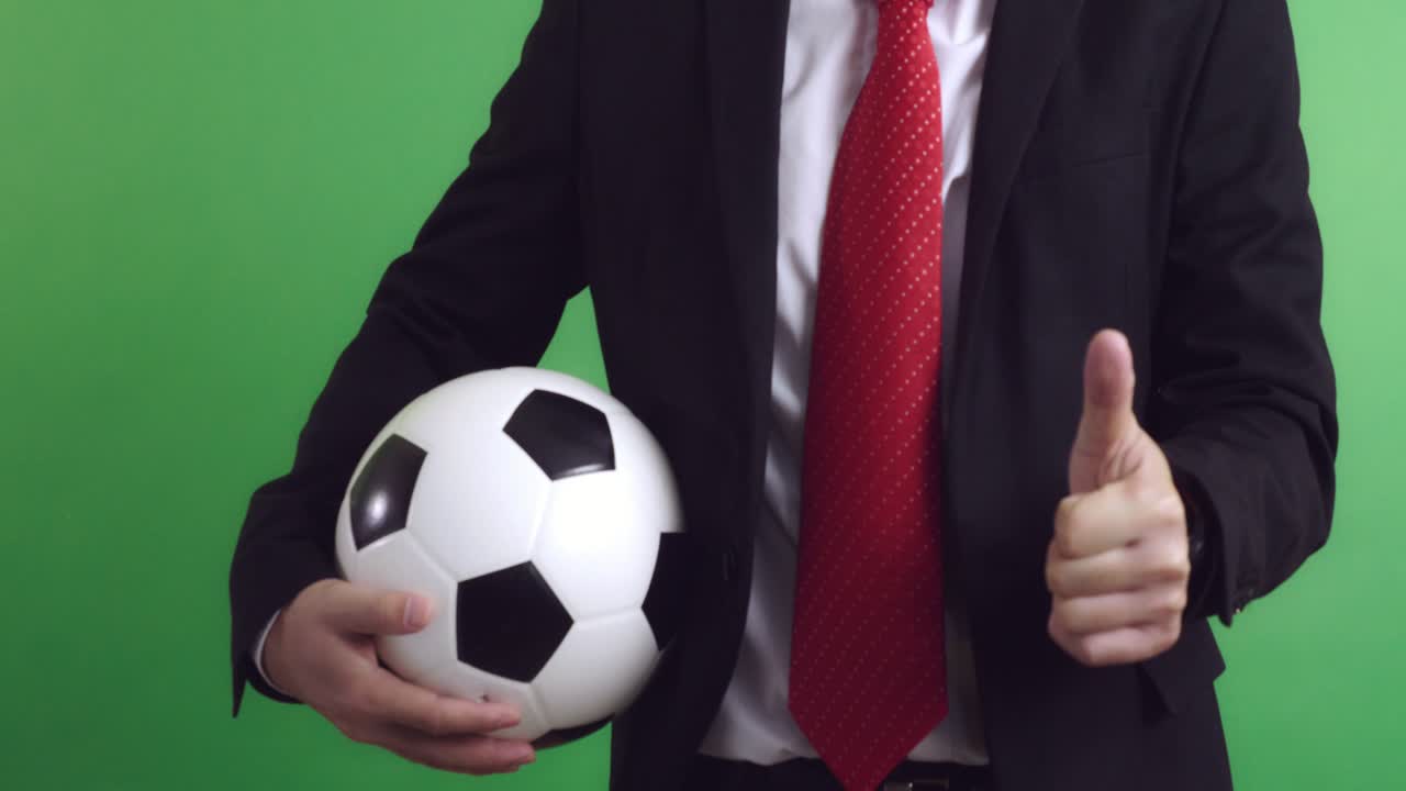 Allenatore di calcio che tiene un pallone da calcio e fa il pollice in su, Video in 4K