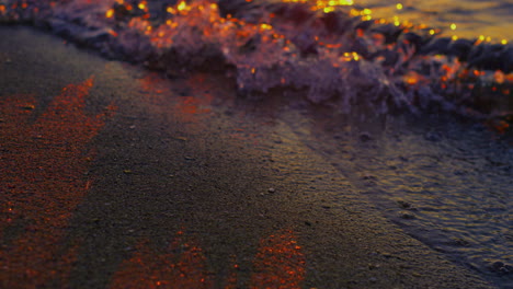 Closeup-calm-sea-waves-reflecting-bright-golden-sunset-at-evening-dusk