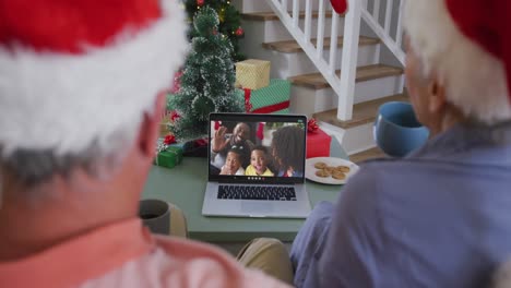 Happy-african-american-senior-couple-on-video-call-with-family-at-christmas