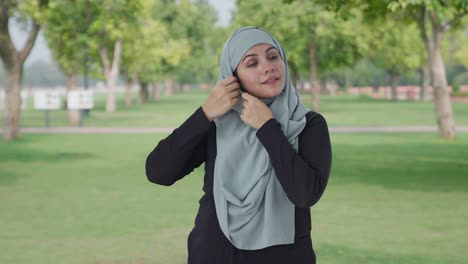 happy muslim woman wearing hijab in park