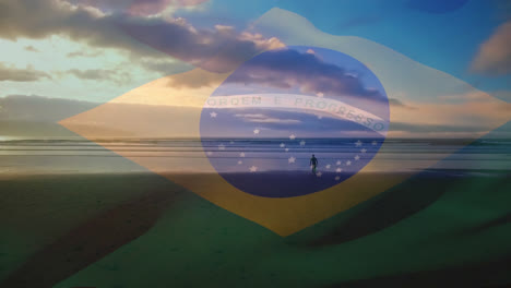 composición digital de agitar la bandera de brasil contra el hombre caminando por la playa