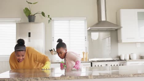 Glückliche-Afroamerikanische-Mutter-Und-Tochter-Putzen-Arbeitsplatte-In-Der-Küche,-Zeitlupe,-Kopierraum