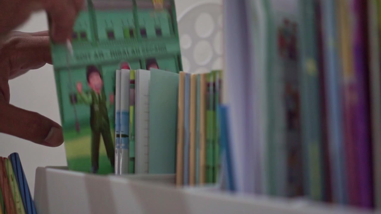 hand grab book from shelf, colorful books arranged, education and organization routine concept.