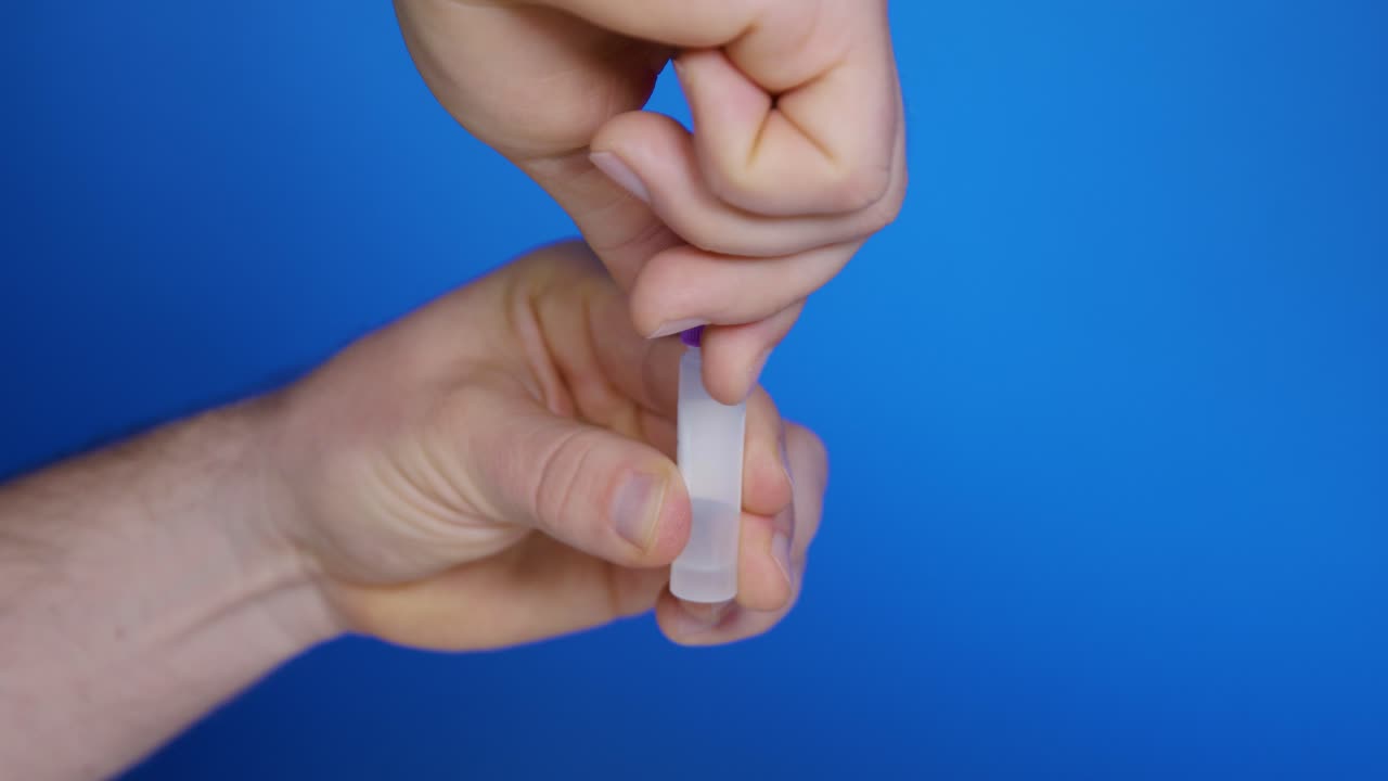 Open cap of transparent plastic vial with extraction solution for self-testing