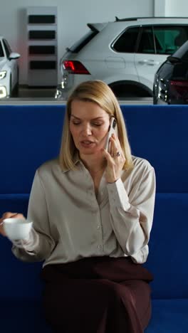 businesswoman on phone in car showroom