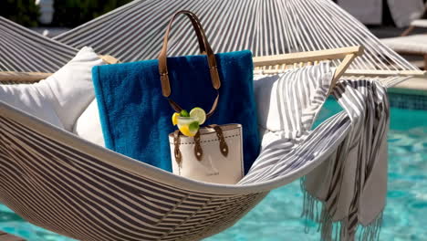 luxury hammock by the pool with accessories and a cocktail