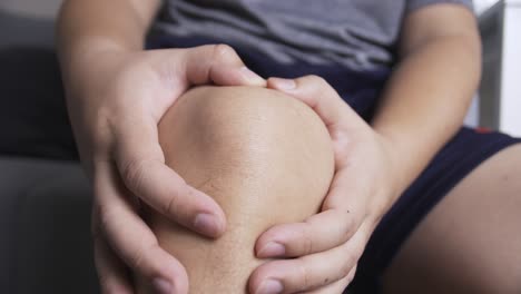 Hand-Auf-Dem-Knie-Mit-Massage,-Die-Unter-Anhaltenden-Schmerzen-Gelitten-Hat