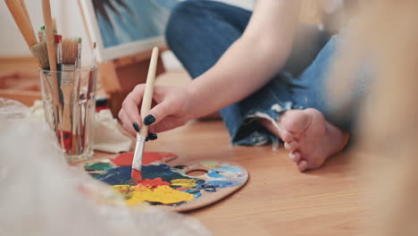 una mujer irreconocible mezclando colores en la paleta de un pintor 2