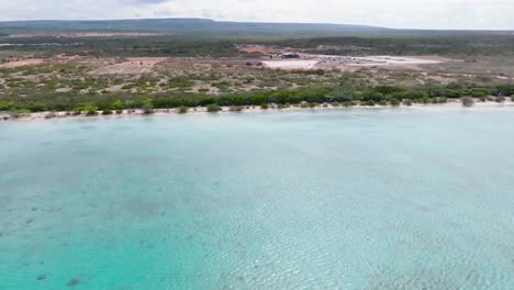 avance aéreo sobre las aguas turquesas de la playa de cabo rojo con área para la construcción de hoteles iberostar y hyatt en el fondo, república dominicana
