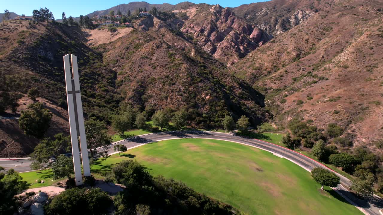 la torre temática de phillips en la universidad de pepperdine rodeada de laderas de montañas rojas toma aérea de marcha atrás