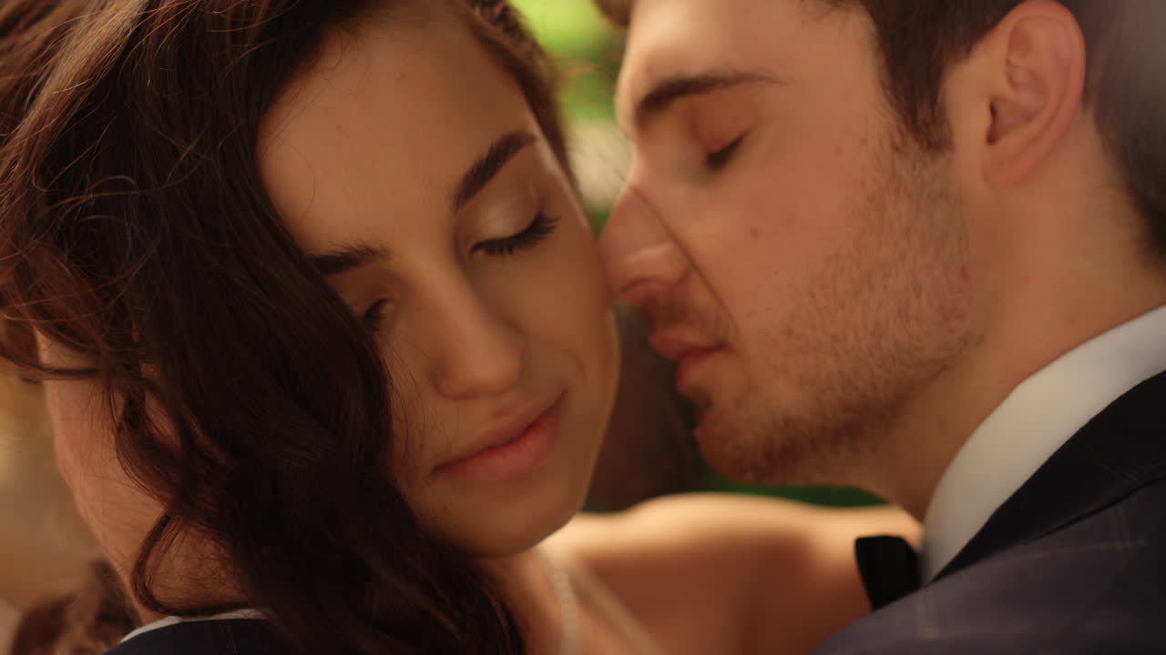 공원에서 포즈를 취하는 사랑스러운 커플. 침착한 신부와 신랑이 결혼식에 서 있습니다.