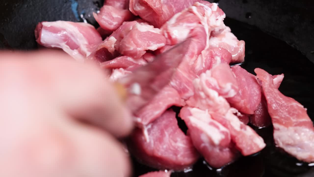 신선한 고기 조각은 뜨거운 프라이팬에 넣습니다.