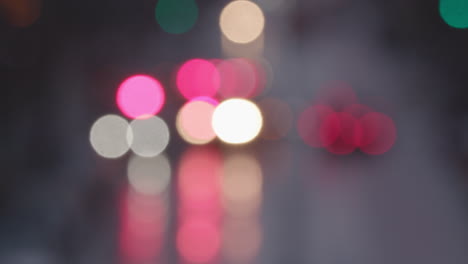 Blurred-slow-mo-of-a-wet-New-York-Manhattan-main-street-with-traffic,-yellow-taxi,-out-of-focus-lights