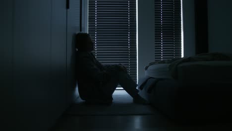 woman sitting alone in bedroom at night