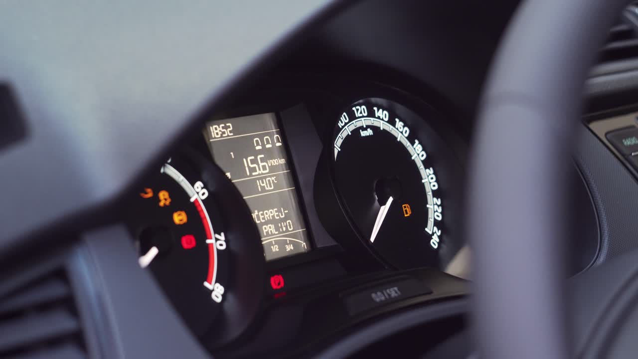 Low fuel level on car dashboard after engine starts, closeup side view