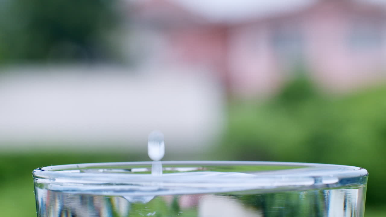 las gotas de agua se forman cuando el agua cae en un vaso lleno de agua limpia y clara